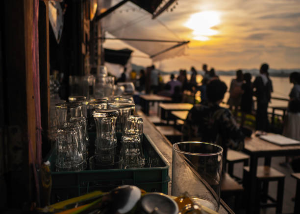 vidro vazio no por do sol, na tabela com espaço para preparar-se para o partido ao longo do rio de mekong. foco suave. - thailand restaurant cocktail bar - fotografias e filmes do acervo