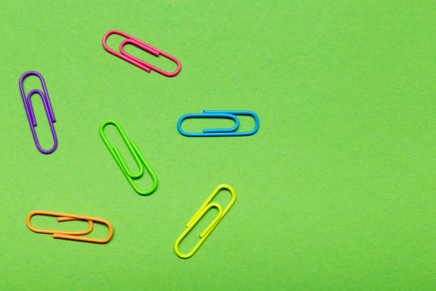 istock minimal office concept, six multi-colored clips laid out on a green background 1140295230