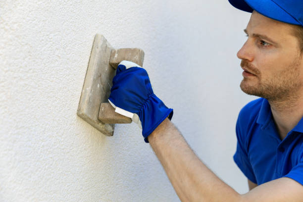 istock man applying decorative facade plaster with trowel on house exterior wall 1140296529