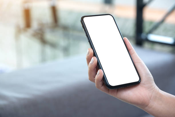 istock a woman's hand holding black mobile phone with blank white desktop screen 1140303332