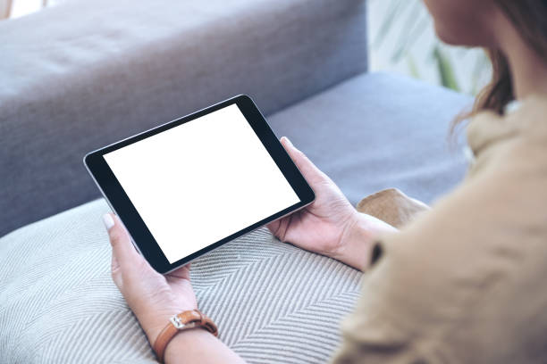 istock a woman holding black tablet pc with blank white desktop screen horizontally while sitting in living room 1140303333