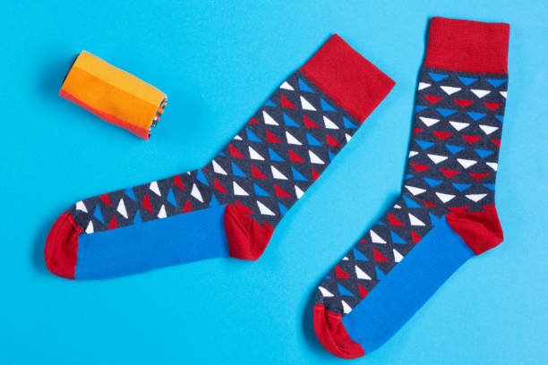 istock a pair of colored socks is lying on a blue background, with yellow socks twisted in a roll, concept 1140304123