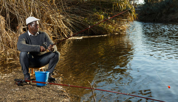 istock Man fishing with rods on river 1140304657