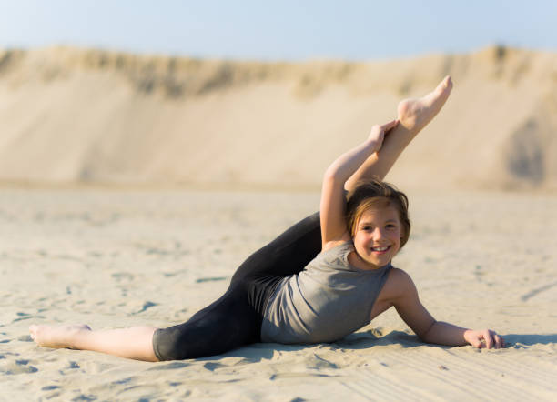 istock Girl practicing gymnastics outdoors on the sand 1140307740
