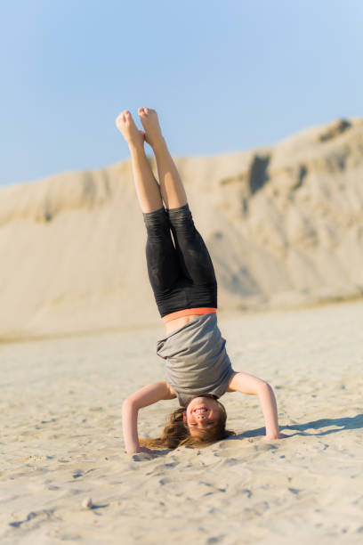 istock Girl practicing gymnastics outdoors on the sand 1140308122