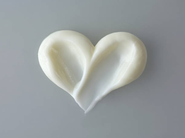 white cosmetic cream white heart shape cosmetic cream on grey background, top view for sale flash stock pictures, royalty-free photos & images