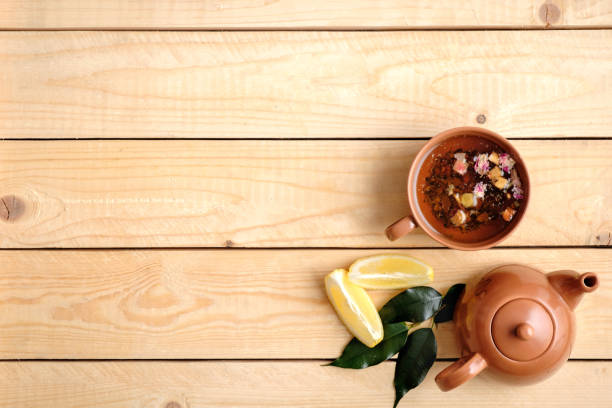 istock Tea ceremony setting on wooden background, tea cup, teapot, lemon and green leaves. Top view, flat lay composition with copy space for text 1140312366