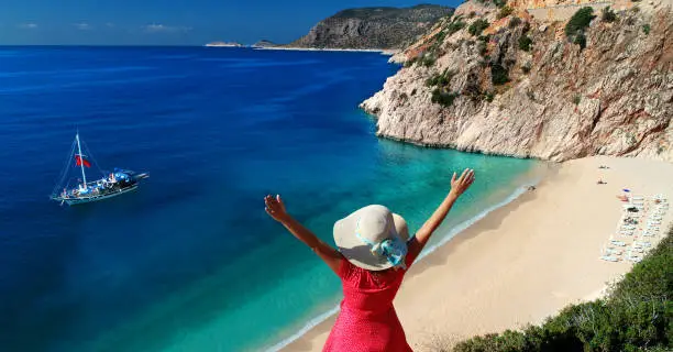 Woman cheering and looking at a beautiful view of Mediterranean sea.