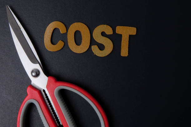 istock Close-Up Of Scissors With Cost Text On Black Table 1140315275
