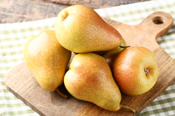 istock Ripe pears with cutting board and napkin on wooden table 1140322917