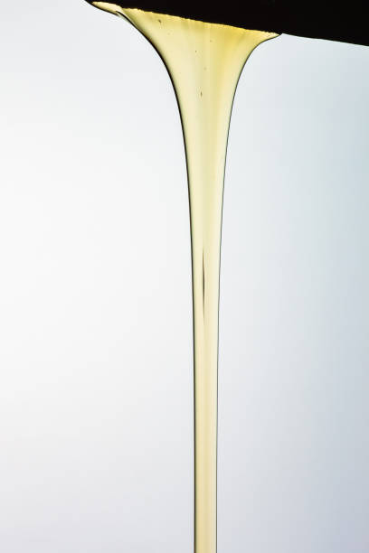 istock Pouring honey or golden liquid on white background. 1140325963