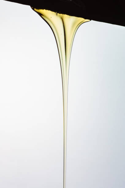 istock Pouring honey or golden liquid on white background. 1140325971