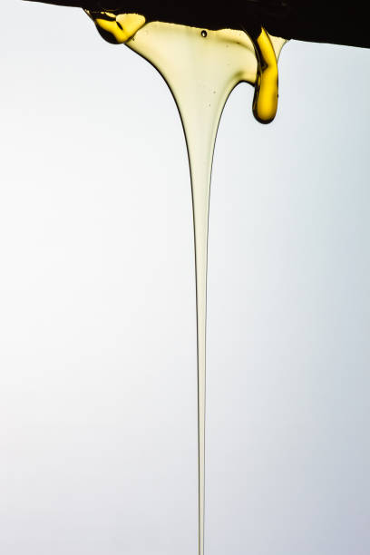 istock Pouring honey or golden liquid on white background. 1140325973