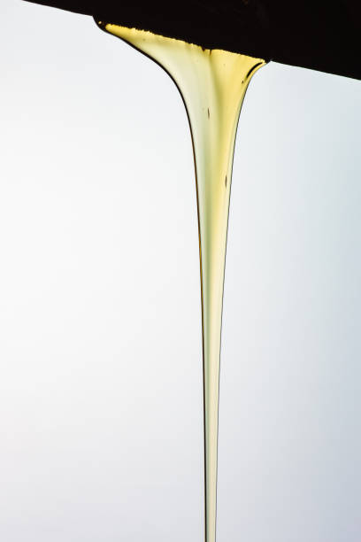 istock Pouring honey or golden liquid on white background. 1140325974