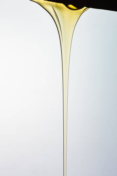 istock Pouring honey or golden liquid on white background. 1140325976