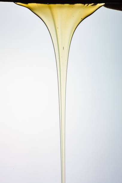 istock Pouring honey or golden liquid on white background. 1140325979