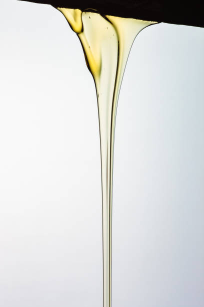 istock Pouring honey or golden liquid on white background. 1140325984
