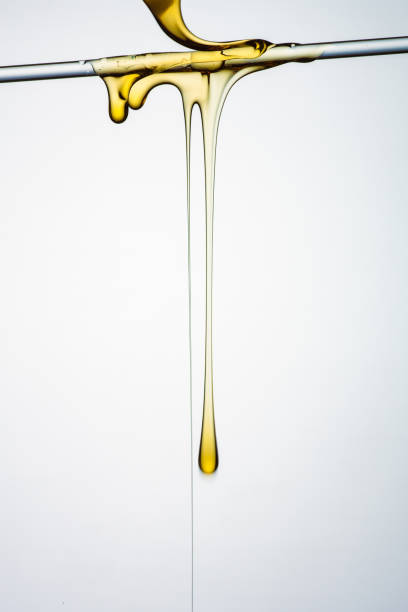 Pouring honey or golden liquid on white background.