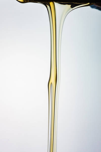 istock Pouring honey or golden liquid on white background. 1140325992