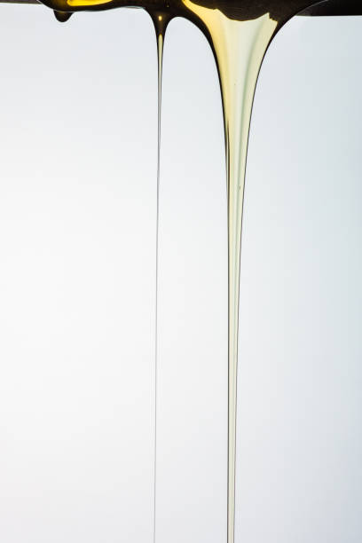 istock Pouring honey or golden liquid on white background. 1140325993