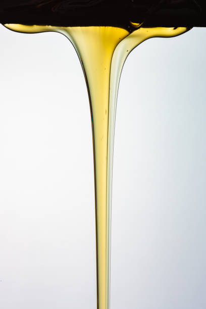 istock Pouring honey or golden liquid on white background. 1140325996