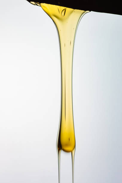 istock Pouring honey or golden liquid on white background. 1140326000