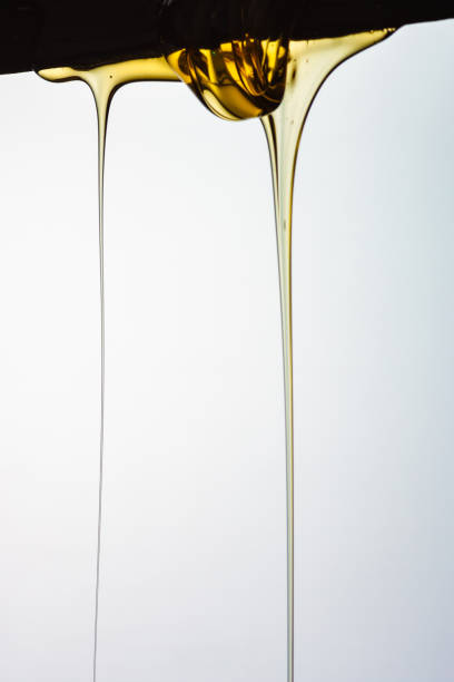 istock Pouring honey or golden liquid on white background. 1140326004
