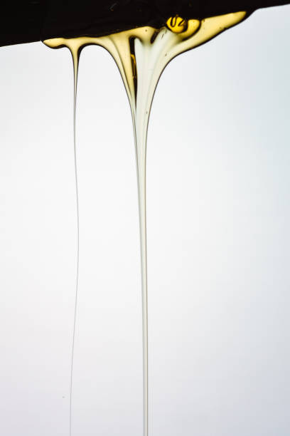 istock Pouring honey or golden liquid on white background. 1140326008