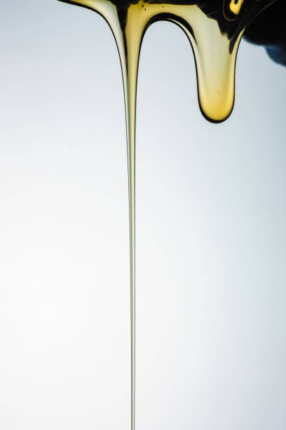 istock Pouring honey or golden liquid on white background. 1140326014
