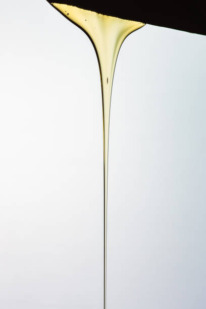 istock Pouring honey or golden liquid on white background. 1140326018
