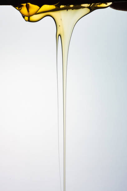 istock Pouring honey or golden liquid on white background. 1140326021