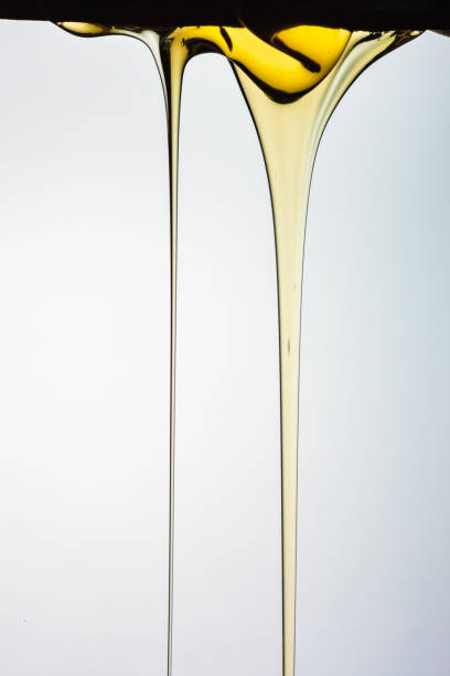 istock Pouring honey or golden liquid on white background. 1140326027