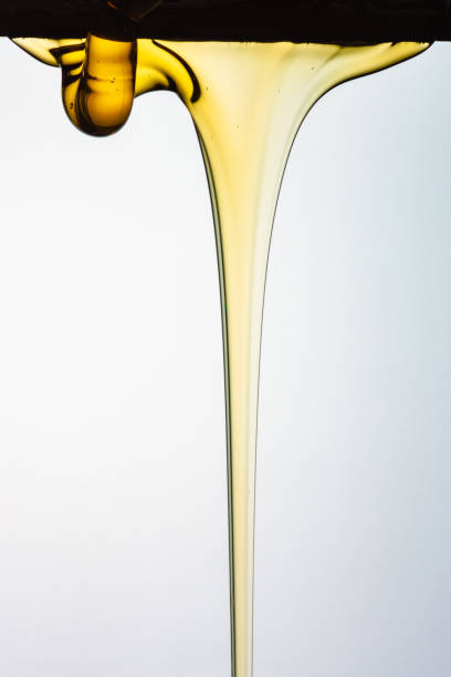 istock Pouring honey or golden liquid on white background. 1140326029