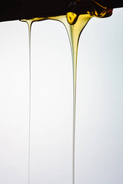 istock Pouring honey or golden liquid on white background. 1140326040
