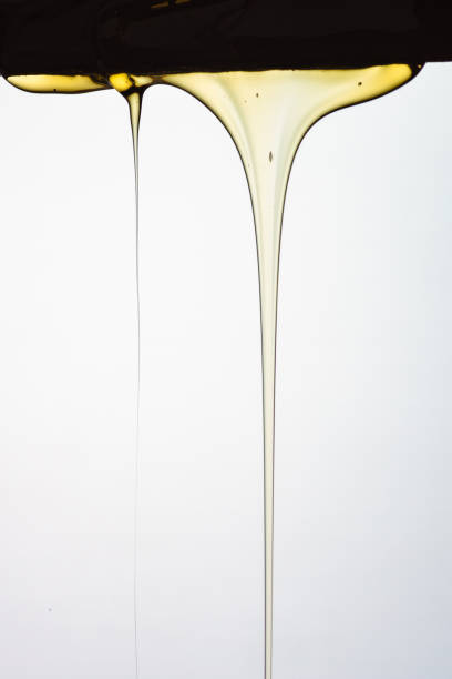 istock Pouring honey or golden liquid on white background. 1140326041