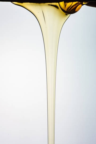 istock Pouring honey or golden liquid on white background. 1140326045