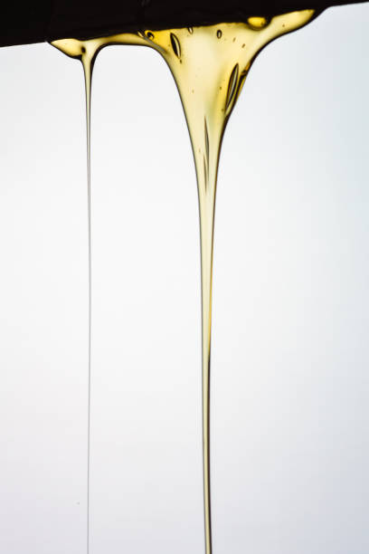 istock Pouring honey or golden liquid on white background. 1140326048
