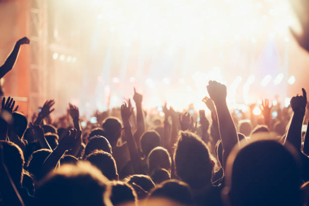 istock Cheering crowd with hands in air at music festival 1140328443