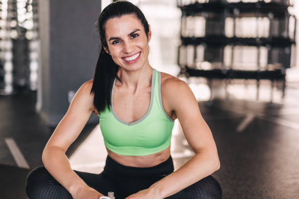istock Cheerful woman sitting in gym 1140328823