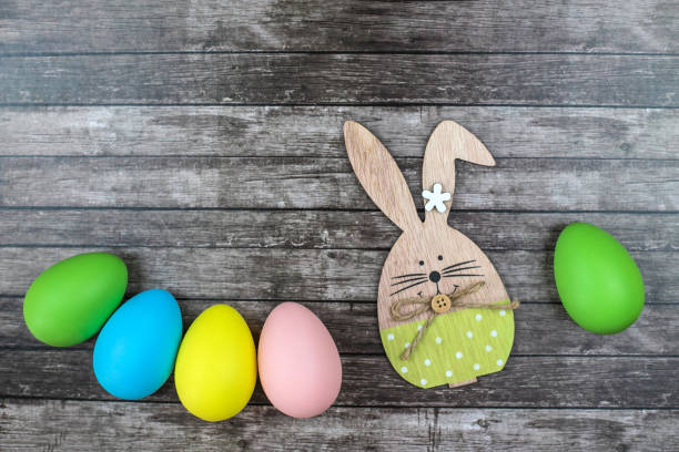 istock Easter eggs and bunny on wooden background. 1140328933