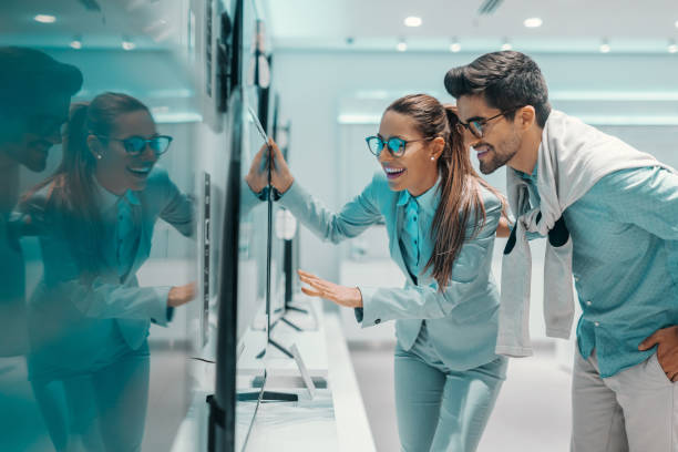 istock Overjoyed attractive multicultural couple dressed elegant found new smart tv for their house. Tech store interior. 1140329723