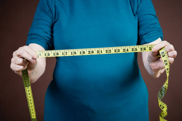 istock Senior hands hold out stretched tape measure, assessing something 1140332893
