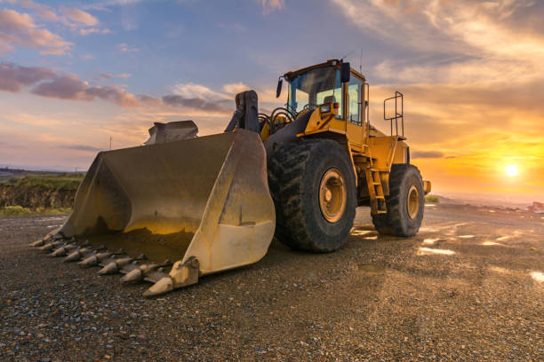 excavadora en movimiento de roca en un sitio de construcción - herramientas de construcción fotografías e imágenes de stock