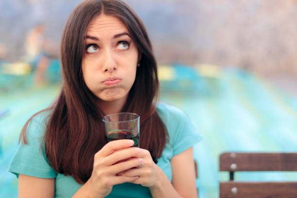 donna annoiata con vetro soda in un ristorante - rolling eyes foto e immagini stock