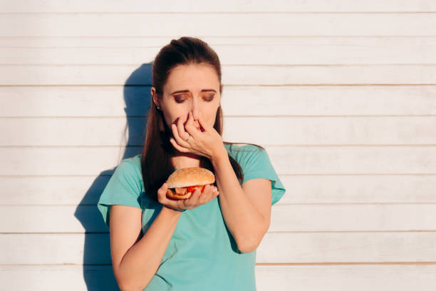 istock Woman Holding a Stinky and Disgusting Burger 1140336381