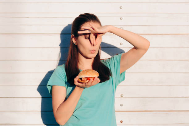 istock Woman Holding a Stinky and Disgusting Burger 1140336392