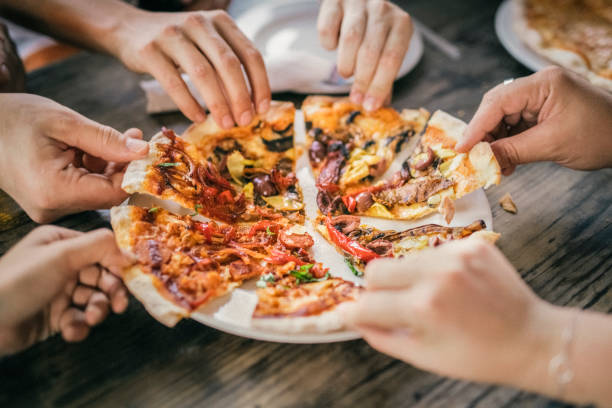 istock Friends sharing fresh pizza at table during party 1140337347