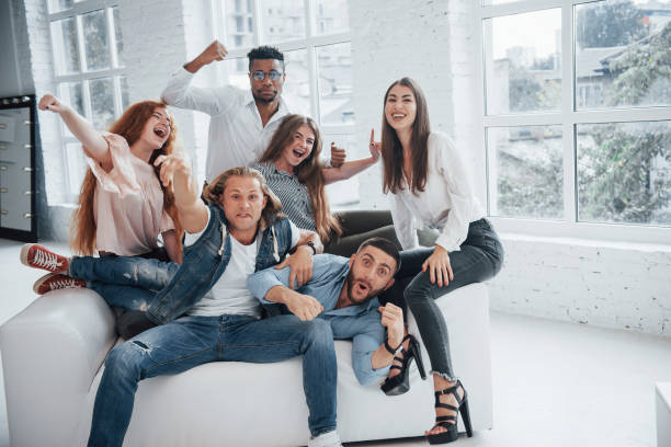 istock Smiling and getting mad. Cheerful young friends having fun in the white interior 1140337363