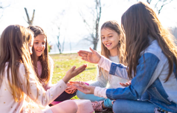 istock Beauty girls sitting on grass 1140339601