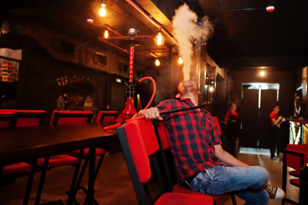 istock Asian man smoke hookah and having rest at lounge bar. 1140339691